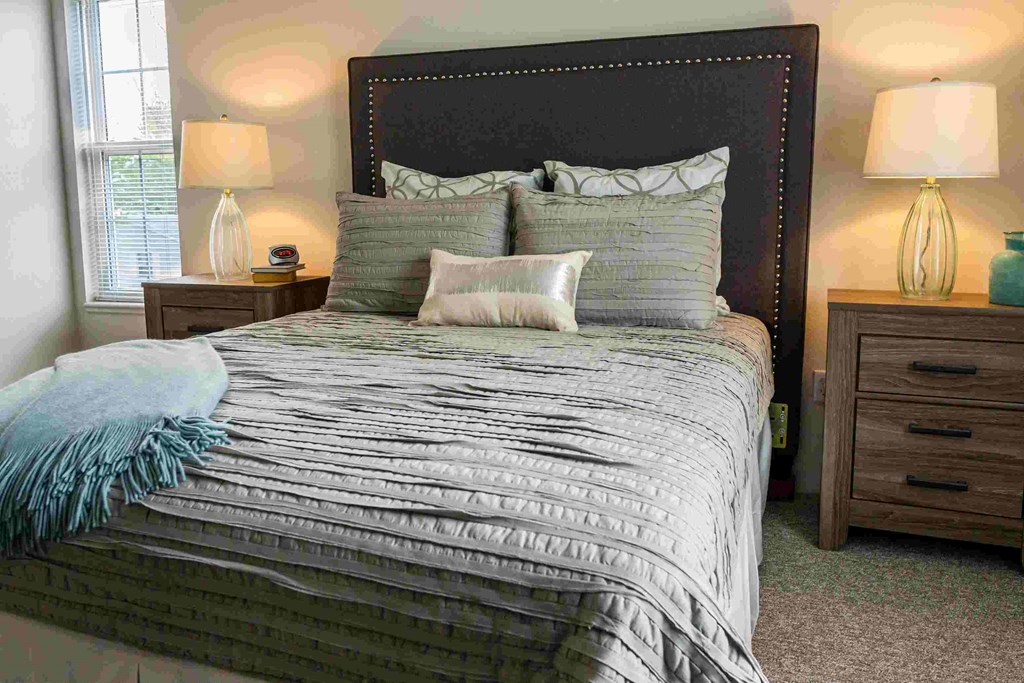 a bedroom with a bed and two night tables