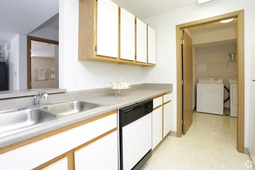 a kitchen with a sink and a door to a laundry room