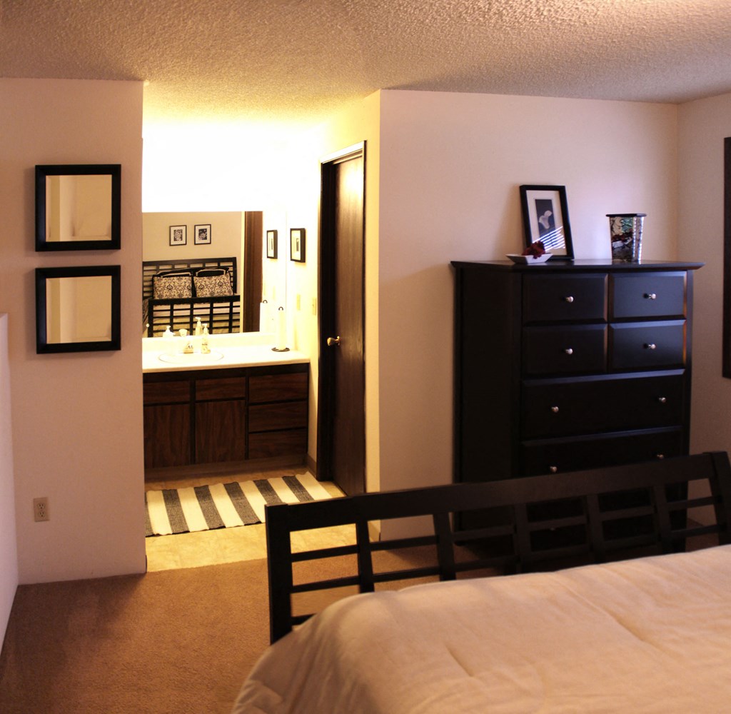 a bedroom with a bed and a bathroom with a sink