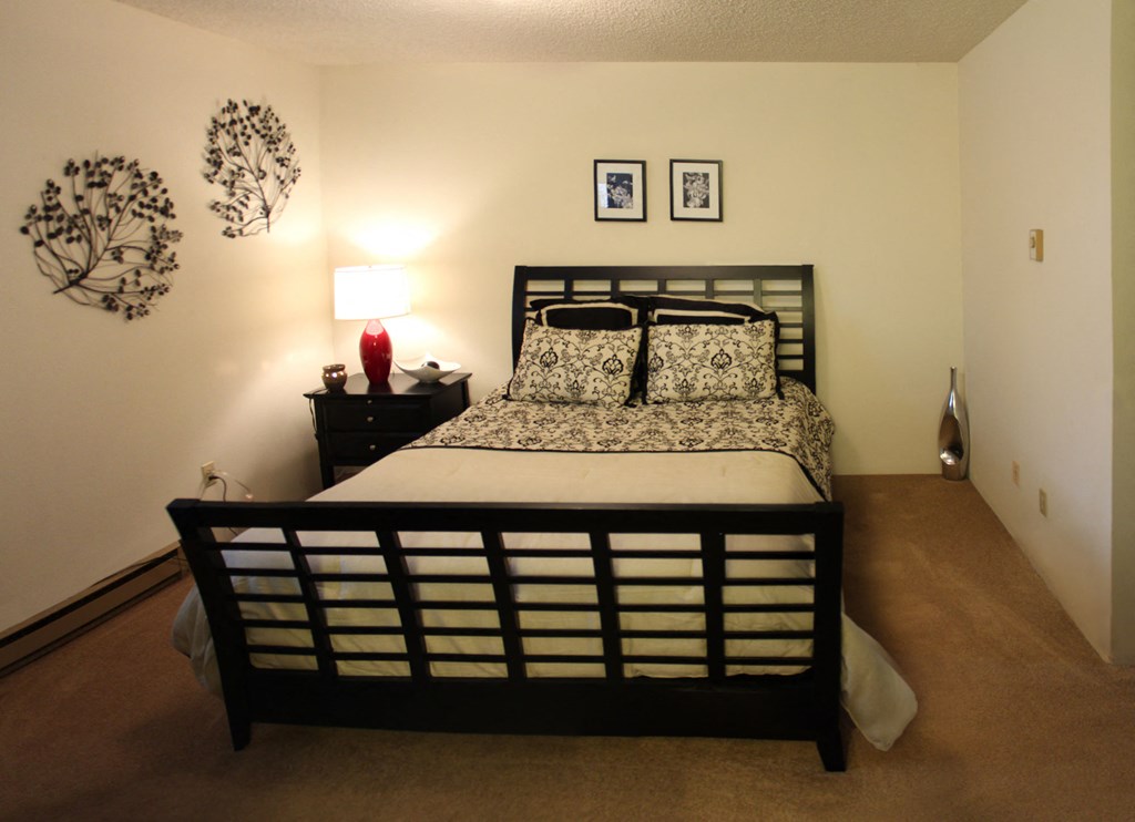 a bedroom with a bed and a nightstand and a window