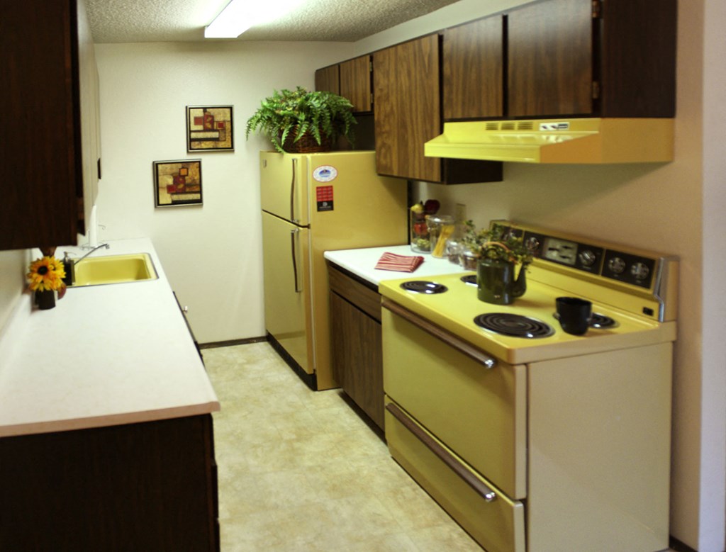 a kitchen with a yellow stove and a refrigerator
