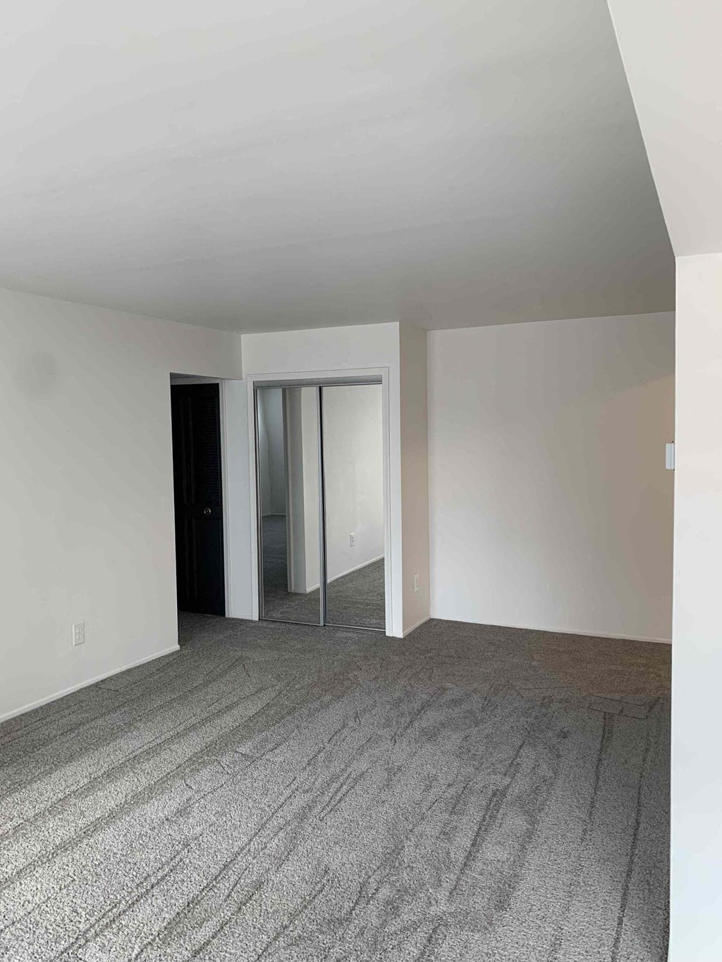 an empty living room with white walls and a carpet