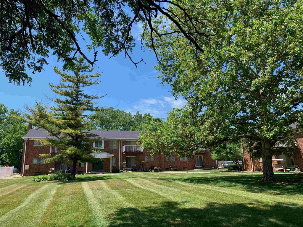 a large brick house with trees in front of it
