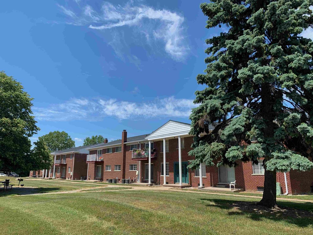 a large brick building with a large tree in front of it