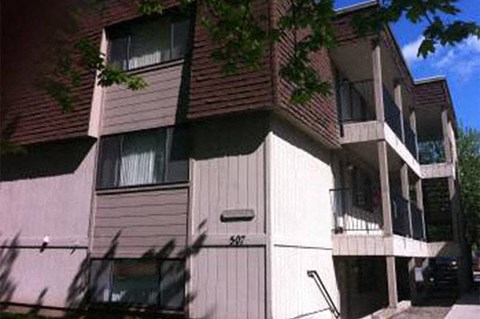 a white and brown apartment building on a street