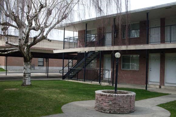 an apartment building with a courtyard and a tree
