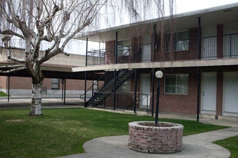 an apartment building with a courtyard and a tree