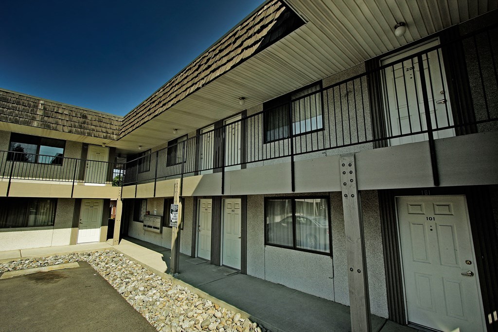 an apartment building with white doors and windows and a courtyard