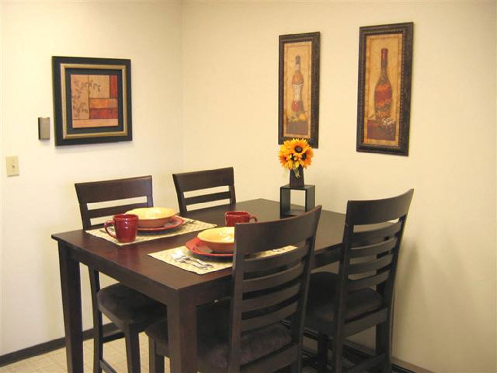 a dining room table with chairs and plates on it