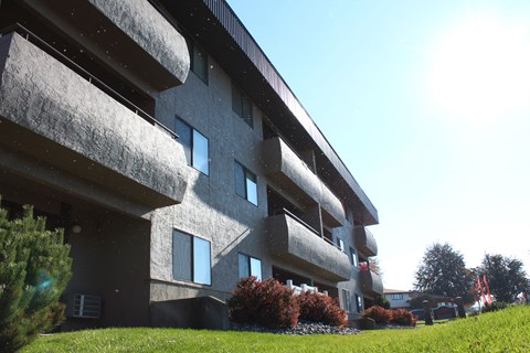 A modern building with a grassy area in front.