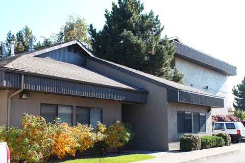 A house with a grey roof and a white car parked in front.