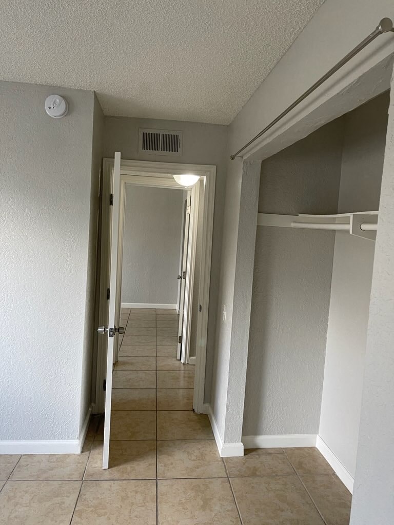 an empty hallway with a door open to a hall way