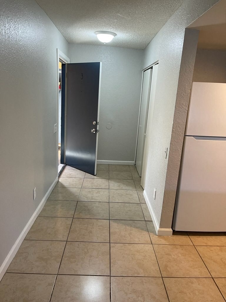 a hallway with a refrigerator and a door