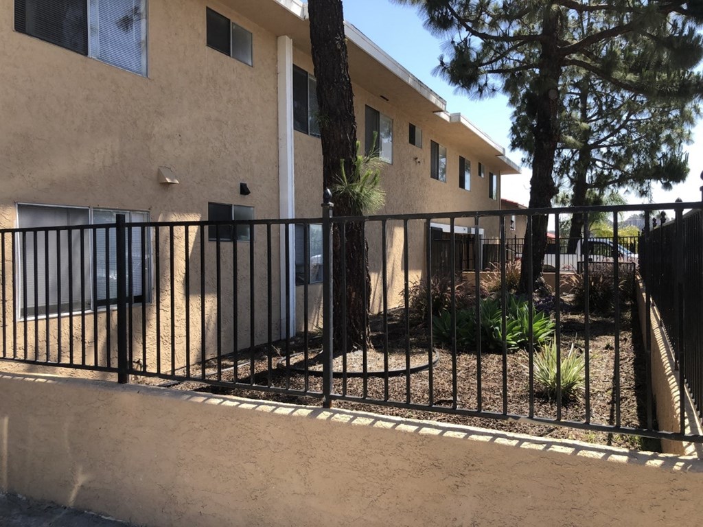 an image of a fence in front of an apartment building