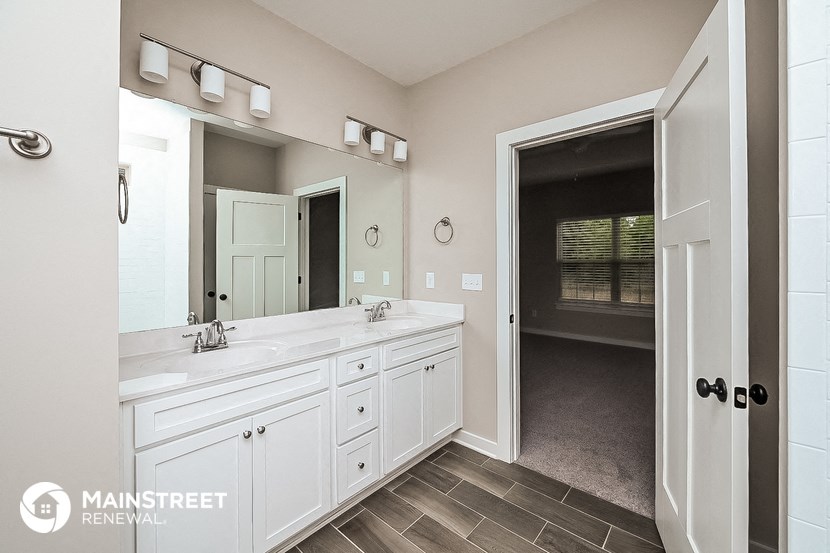 a large white bathroom with a large mirror and a sink
