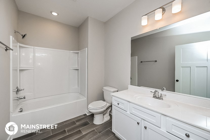 a bathroom with a white sink and a toilet and a bath tub