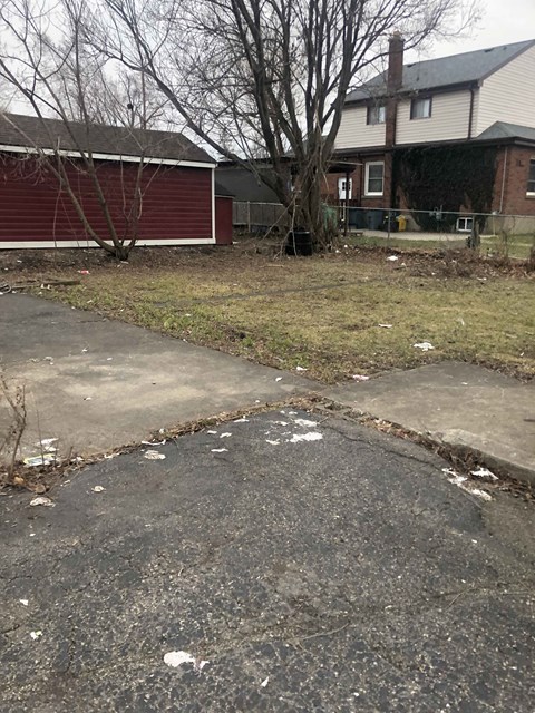 a sidewalk in front of a house with trash on it