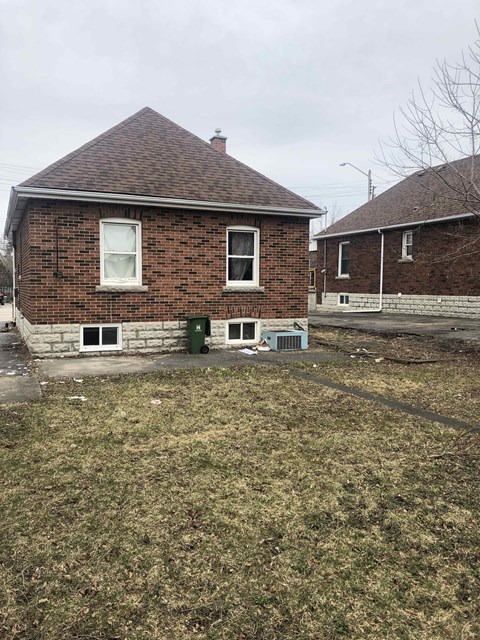 a brick house with a yard in front of it