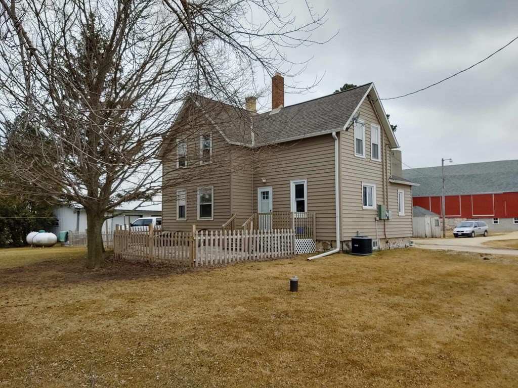 a house with a fenced in yard and a red barn