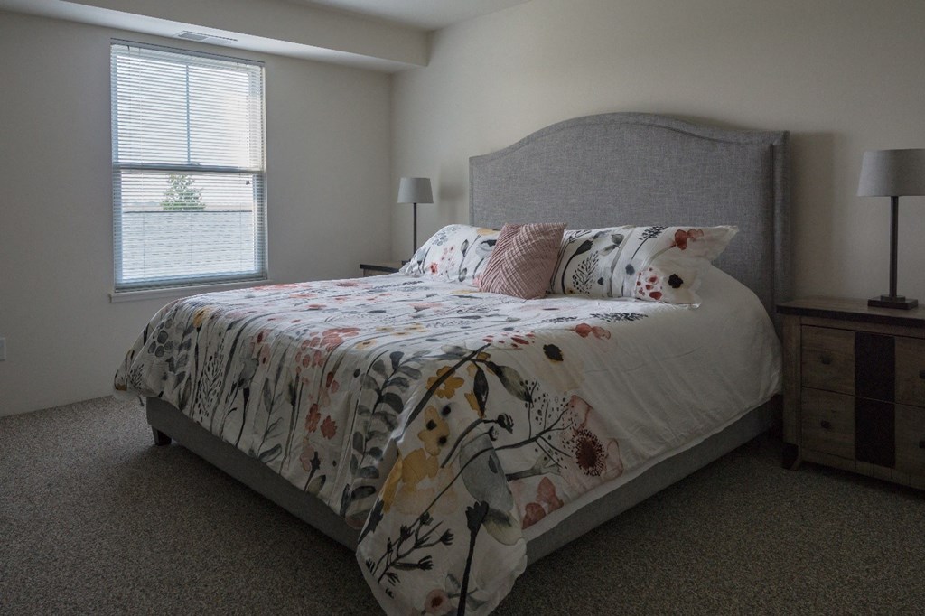 a bedroom with a bed and a dresser and a window
