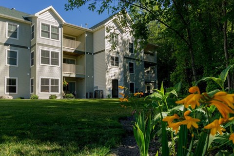 an apartment building with yellow flowers in front of it