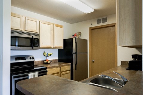 a kitchen with stainless steel appliances and a black refrigerator