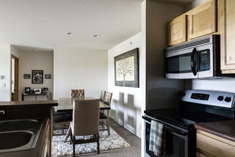a kitchen and dining room with a table and chairs and a microwave and a stove