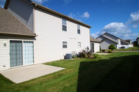 A house with a blue door and a green lawn..
