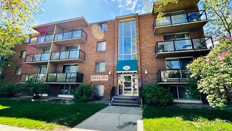 a brick apartment building with a sidewalk in front of it