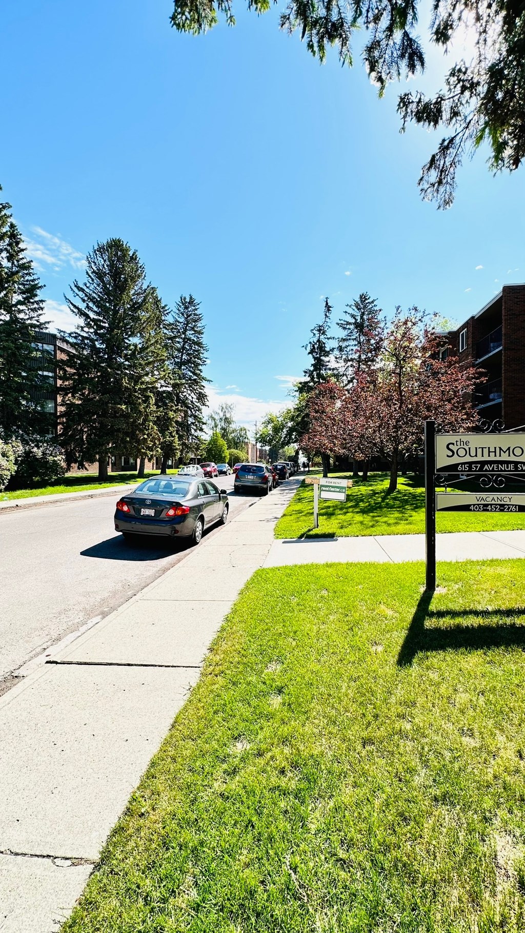 a city street with cars parked on the side of a sidewalk