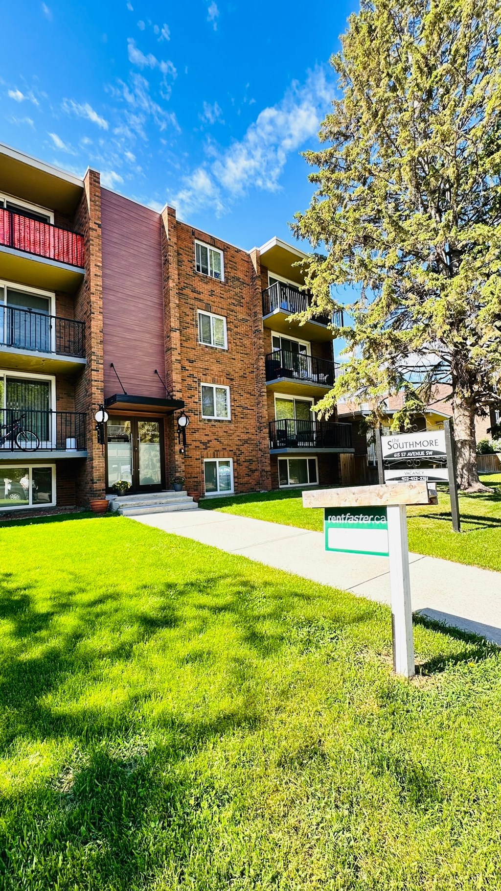 a building with a green lawn and a sign in front of it