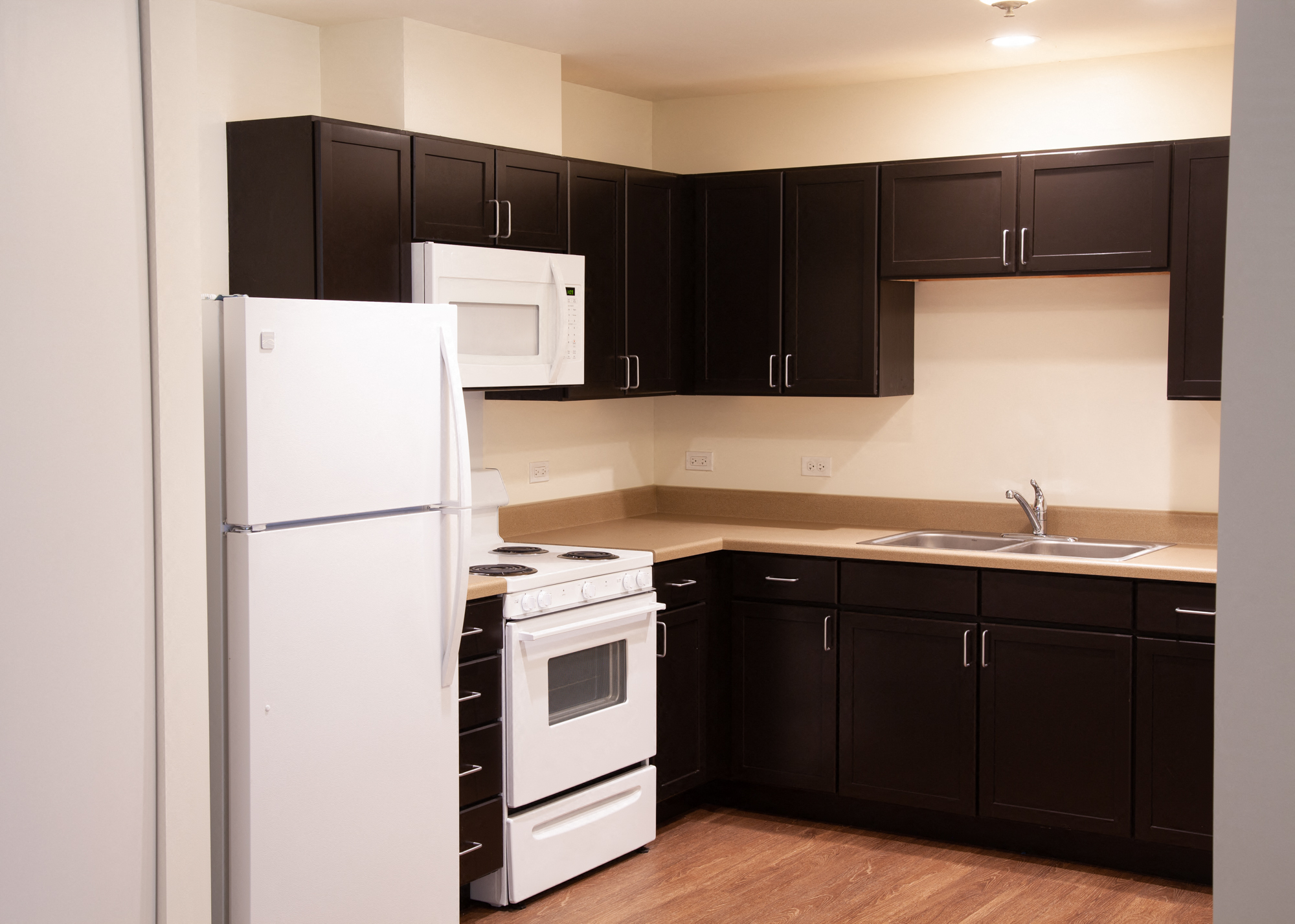 a kitchen with black cabinets and white appliances and a refrigerator