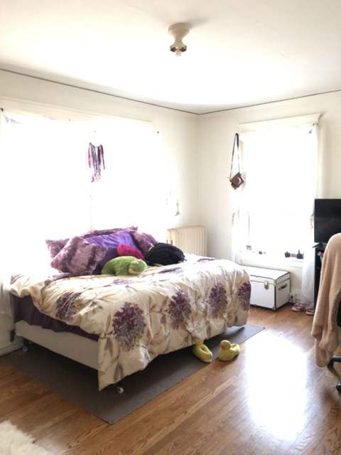 A bedroom with a bed, a dresser, and a window.