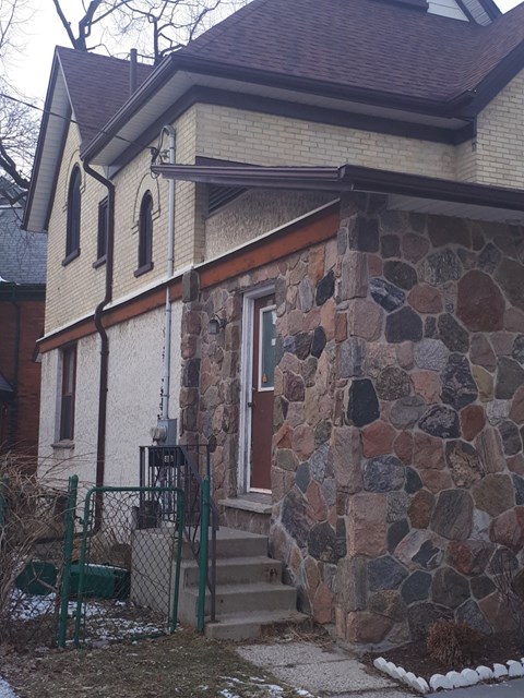 a house with a stone wall and steps to the door
