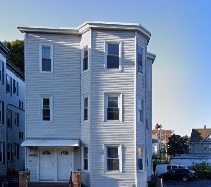 a white house with a car parked in front of it