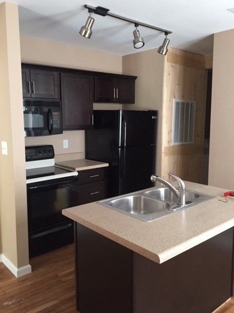 a kitchen with a sink and a stove and a refrigerator