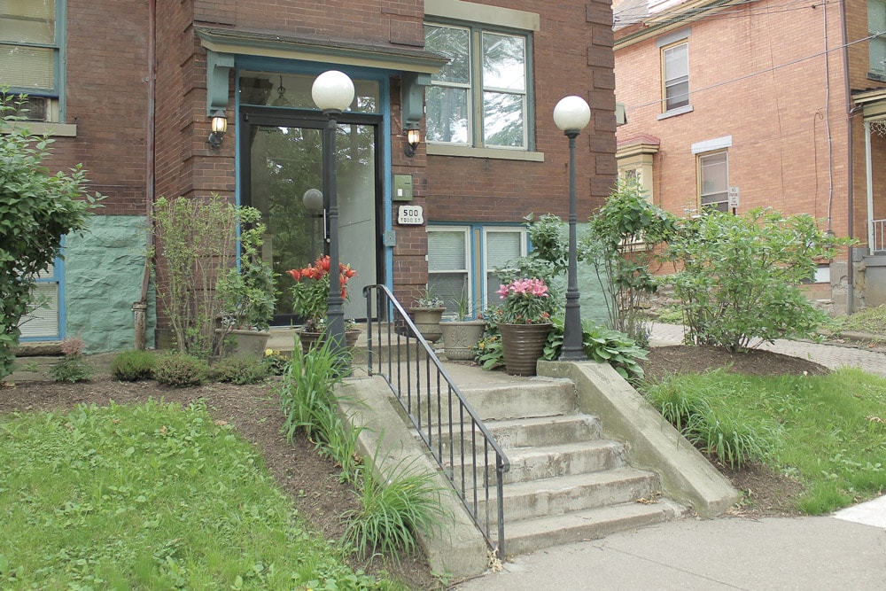 A brick house with a green lawn in front.