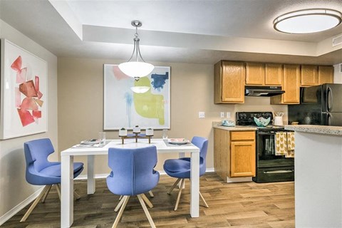 A kitchen with a table and chairs and a painting on the wall.
