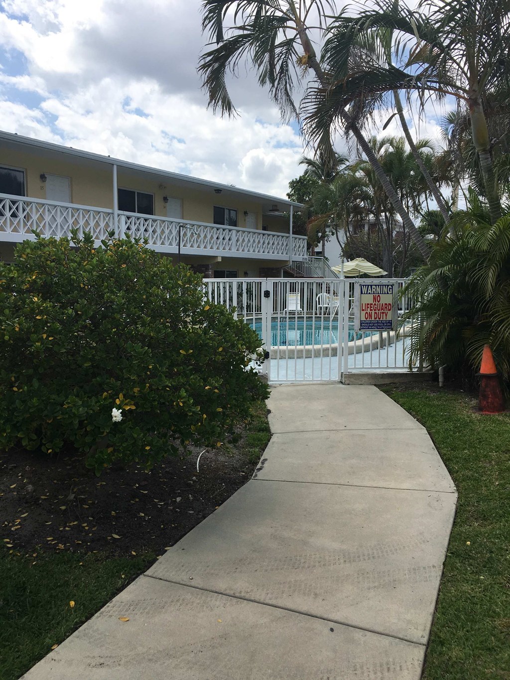 a sidewalk in front of a building with a pool