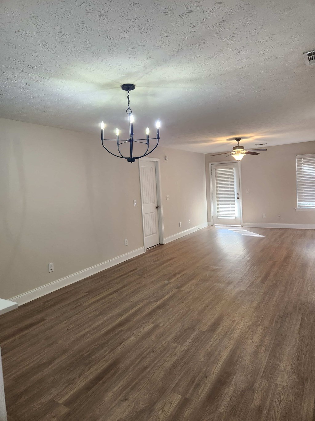 A room with wooden floors and a chandelier.