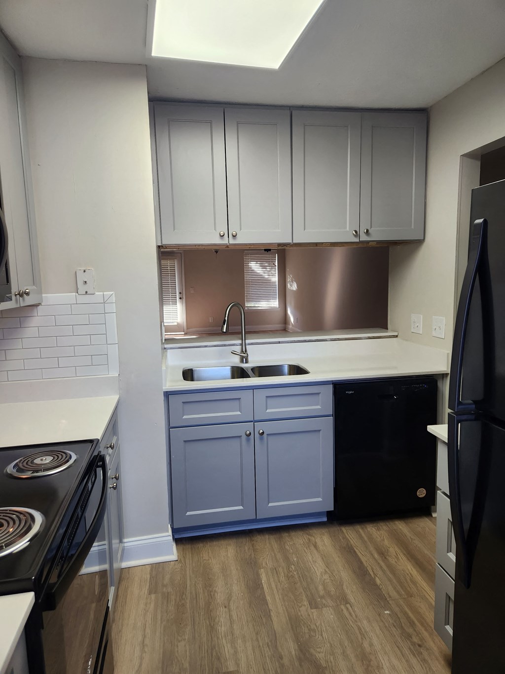A kitchen with a black fridge and a black stove.
