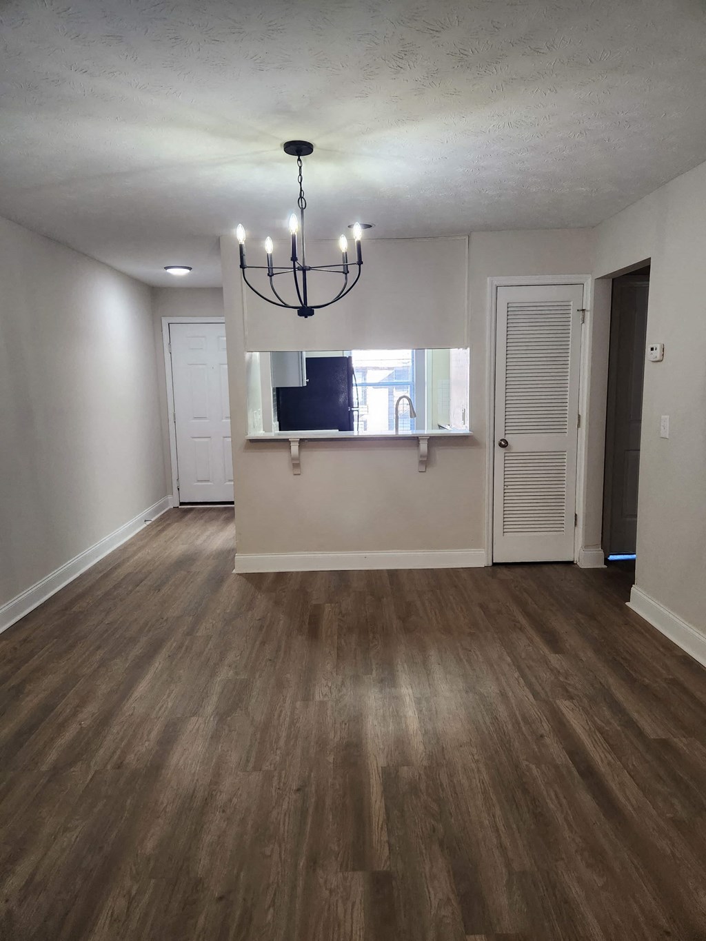 A room with wooden floors and a chandelier.