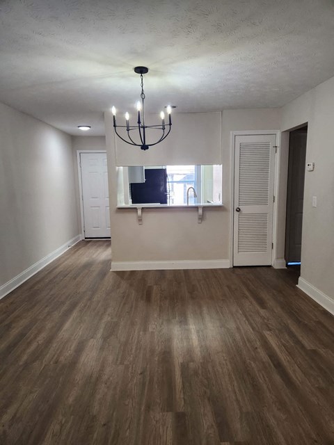 A room with wooden floors and a chandelier.