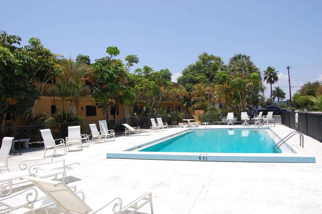 the pool is surrounded by chairs and a white pool
