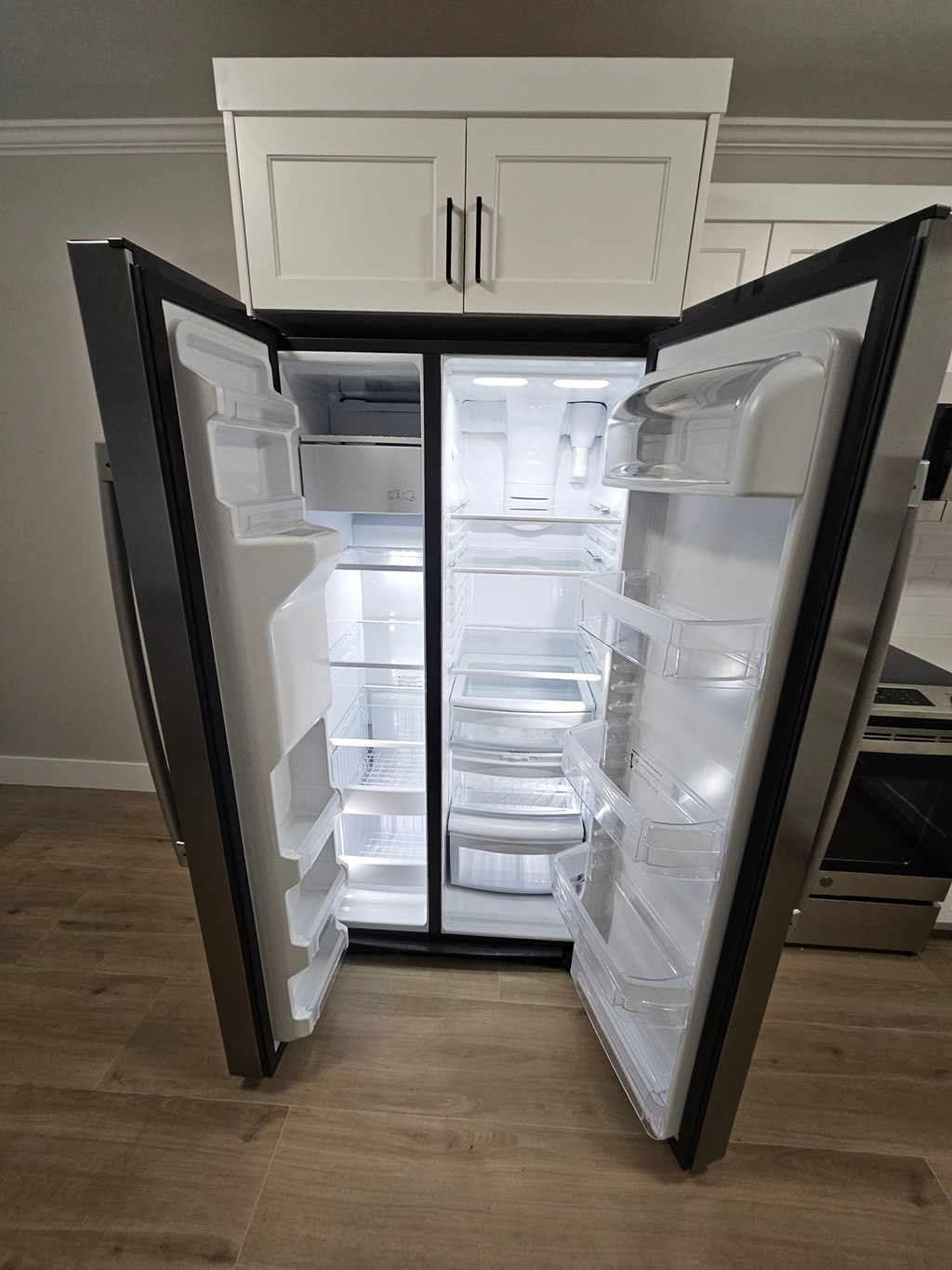 a refrigerator with its doors open in a kitchen
