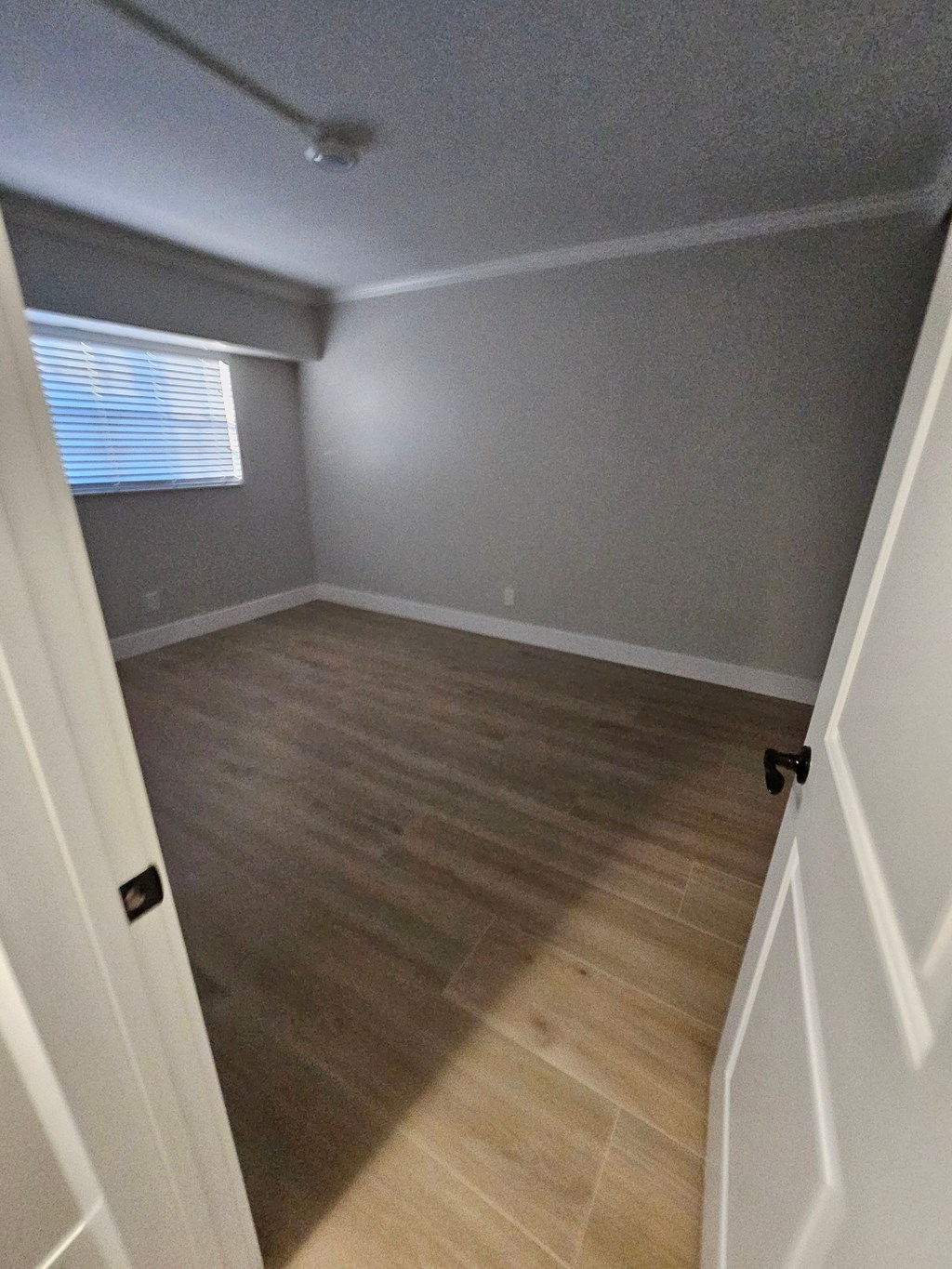 an empty room with wood floors and a window