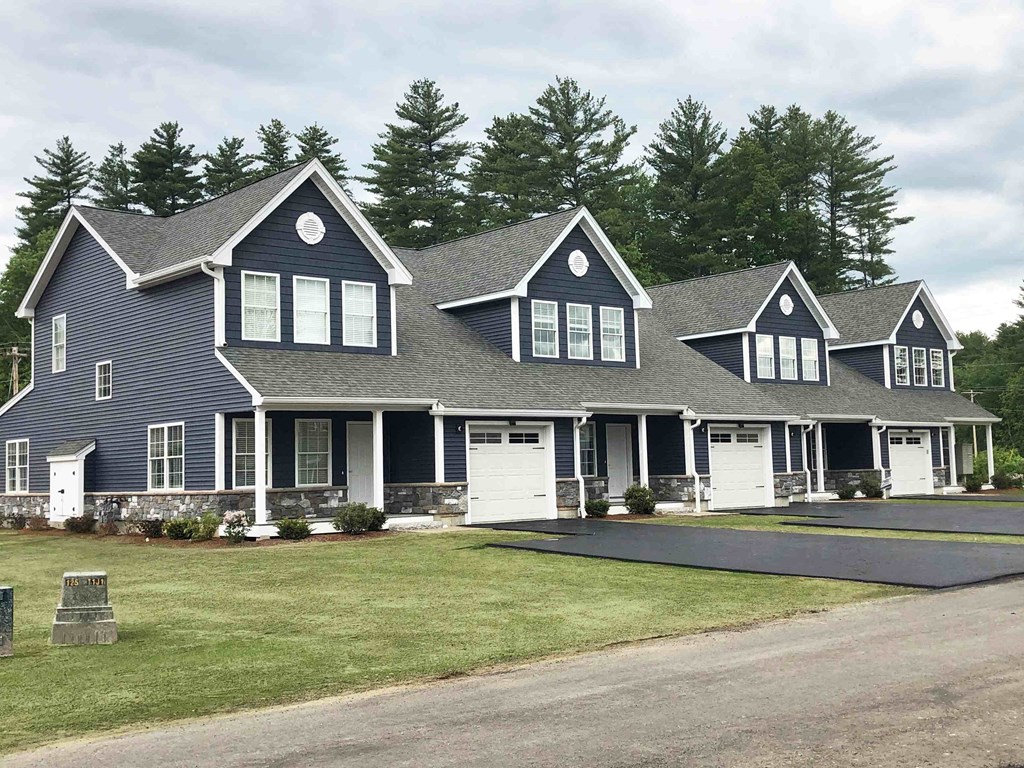 a large house with white garage doors and a lawn