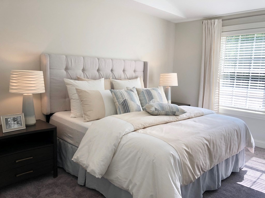 a bedroom with a bed and two lamps