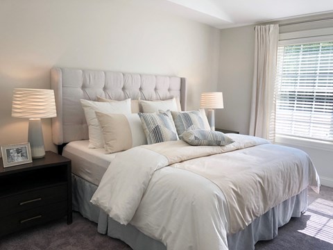 a bedroom with a bed and two lamps