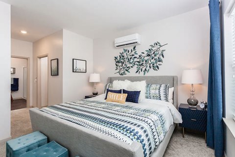 a bedroom with a bed and a plant on the wall